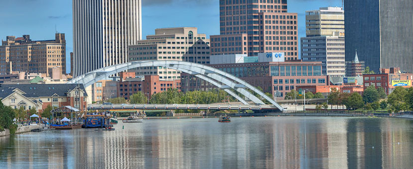 A bridge over the water in front of some buildings.